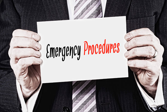 Man holding a sign that says "Emergency Procedures"