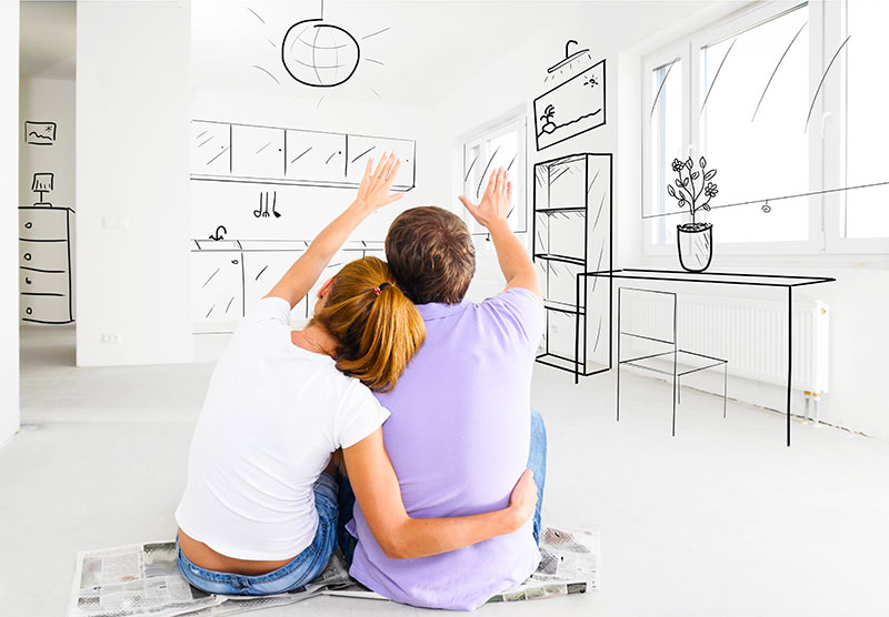 Man and woman sitting on the floor, looking at their apartment