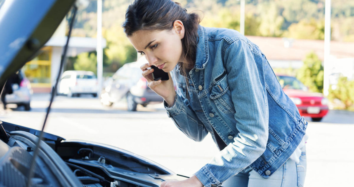 Woman with car trouble using mobile phone