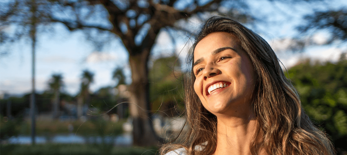 Happy woman outside near trees