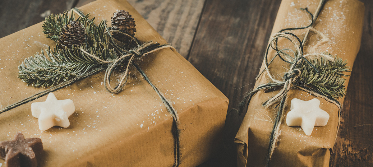 Two gifts wrapped in brown paper and greenery. Image credit: Ylanite Koppens